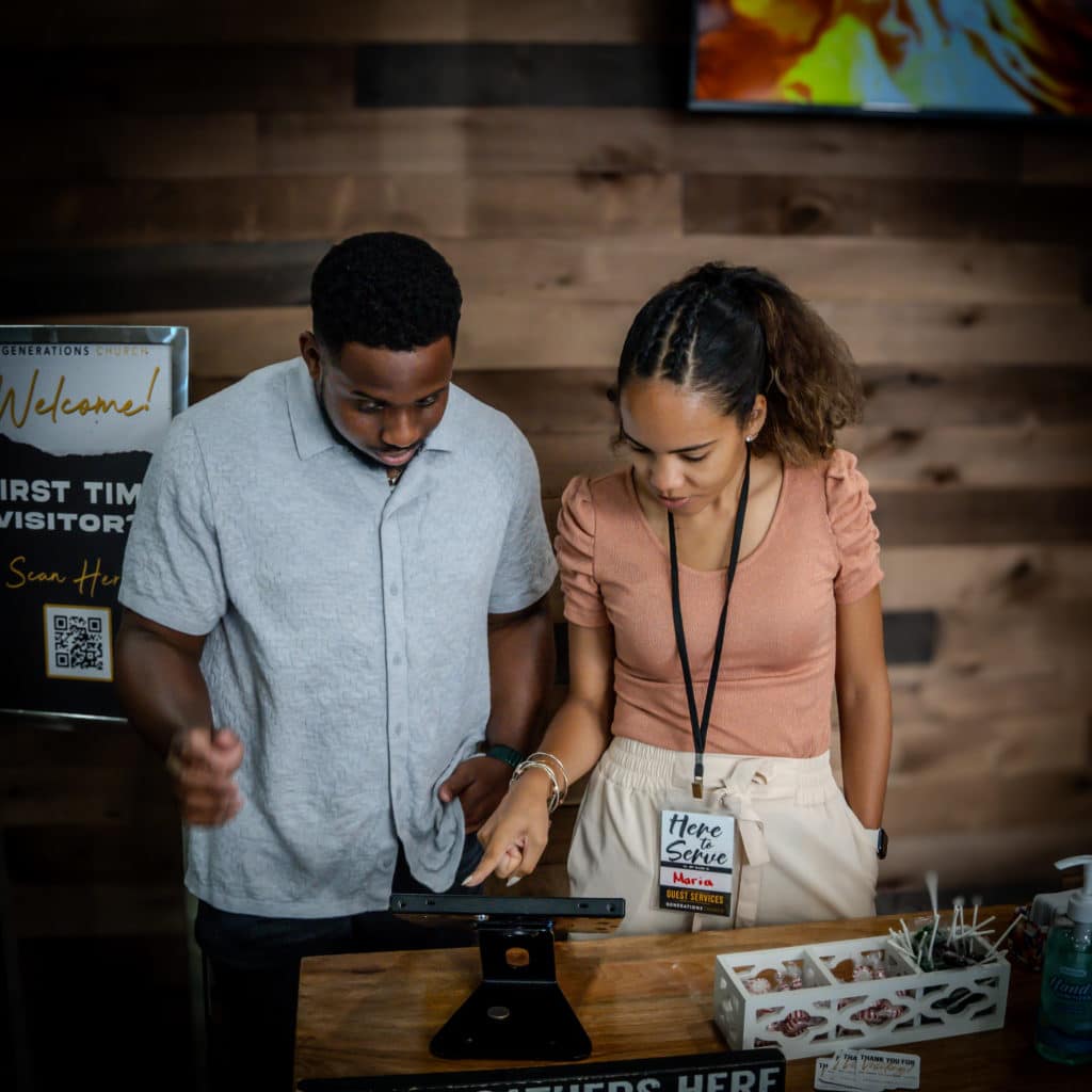 Young man and lady using a kiosk at Generations Church
