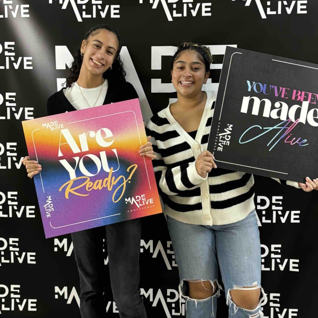 Two teenage girls holding signs at the Made Alive Conference